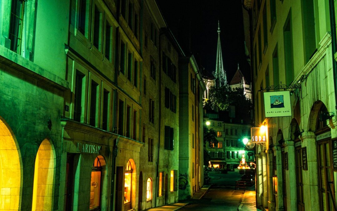 a city street at night with a clock tower in the background